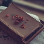 Livros antigos sobre mesa de madeira em sala iluminada por luz natural