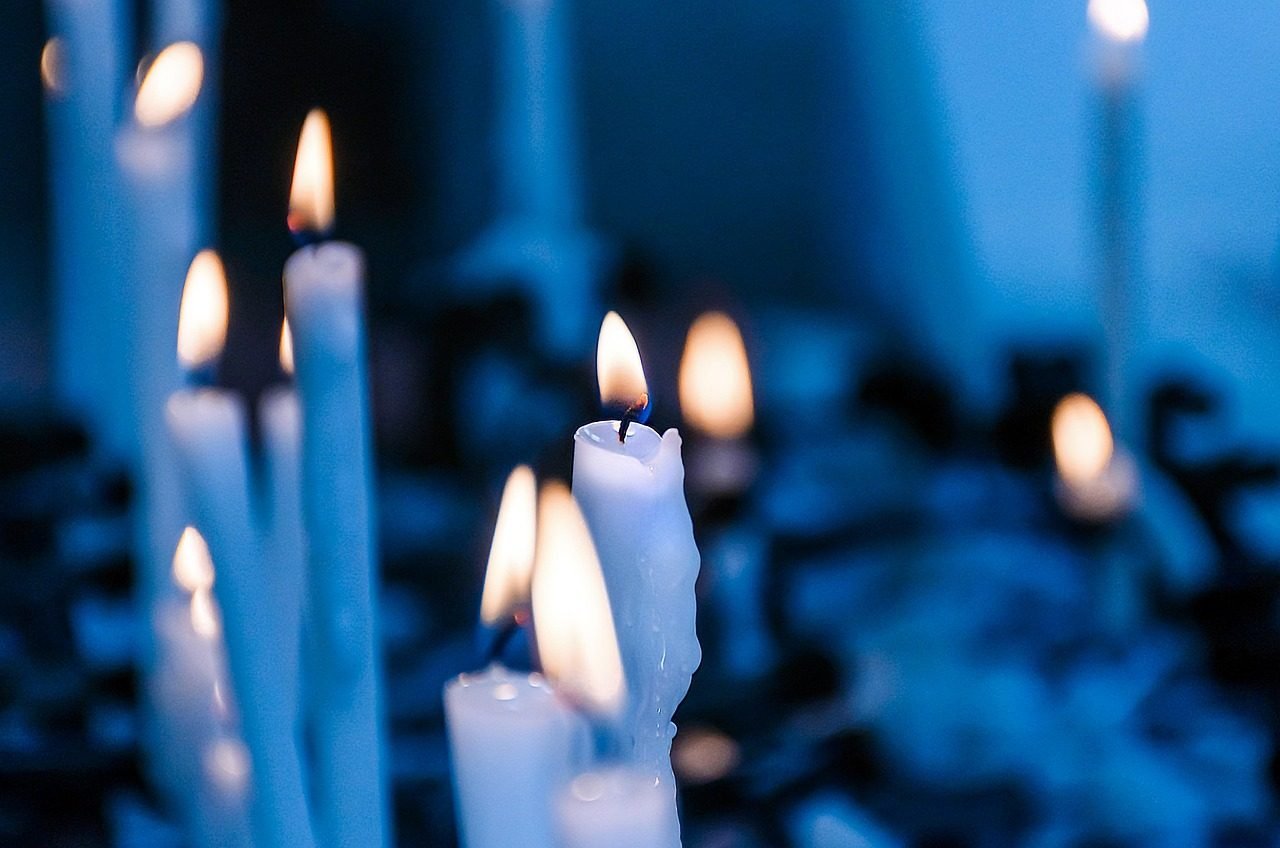 Luz suave de vela e flores transmitindo serenidade e reflexão em oração