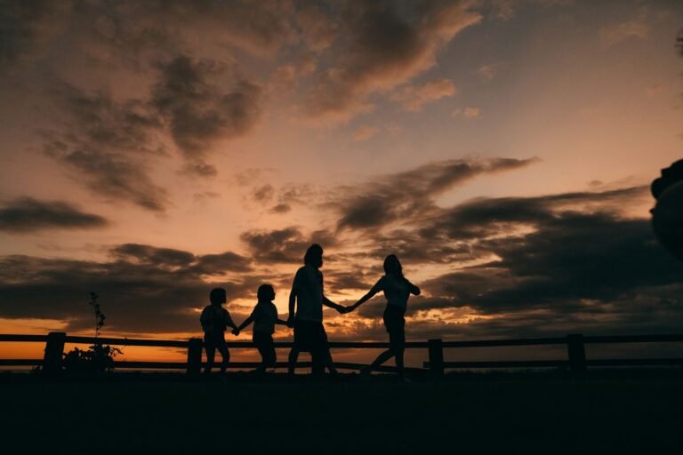 Pessoas reunidas em momento de afeto e paz ao pôr do sol.