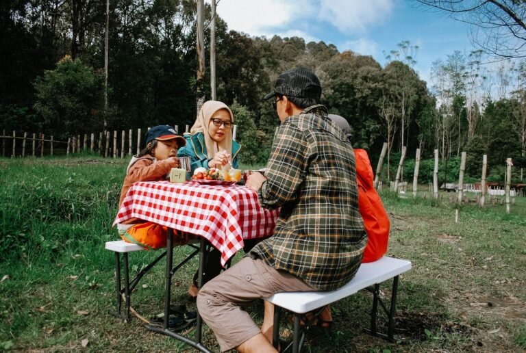 Família reunida almoçando à mesa de domingo em ambiente simples e iluminado