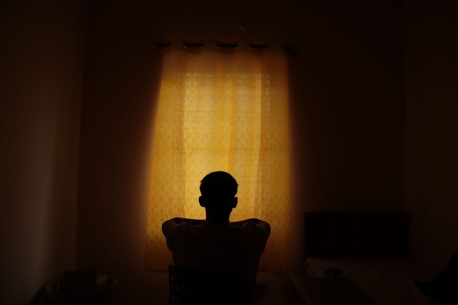 Pessoa serena sentada em reflexão tranquila em uma sala acolhedora e iluminada