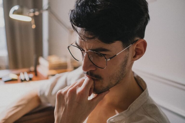 Homem observa planta na escrivaninha, à luz natural